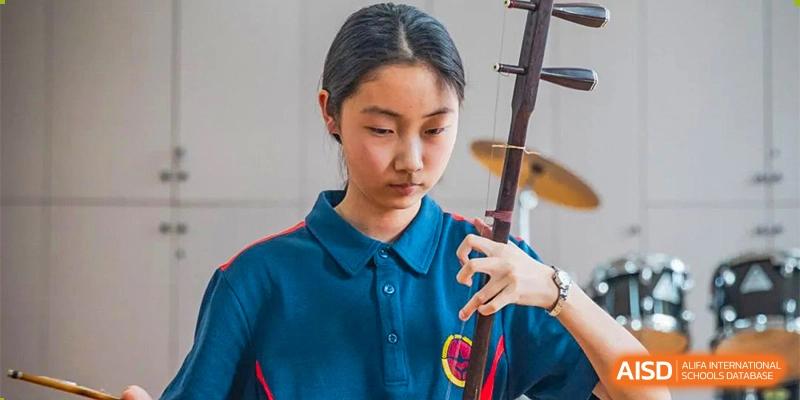 A student from Ningbo Huamao International School focusing on a project in a classroom.