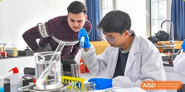 A Qingdao MINGDE School student using a pipette for a science experiment in a lab.