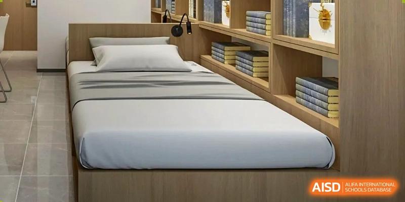 A dormitory room at Qingdao MINGDE School with a bed and a built-in bookshelf.
