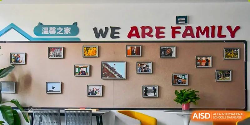 A wall decorated with artwork and pictures at Qingdao MINGDE School.