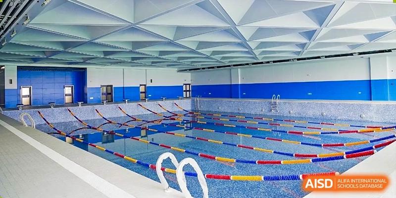 An empty swimming pool at Qingdao MINGDE School, with lanes marked and ready for use.