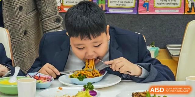 A young Qingdao MINGDE School student enjoying a meal.