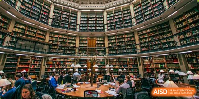 Students from Dulwich College Shanghai Pudong studying in a grand, historic-looking library.