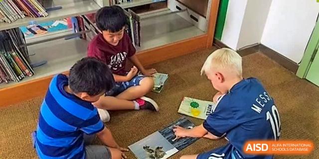 Students read a book on the floor during a classroom activity at Qingdao No.1 International School of Shandong Province (QISS).