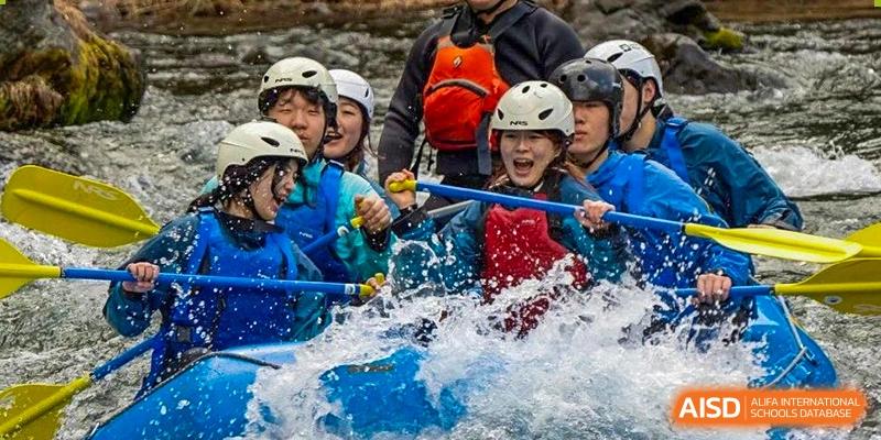 Students and adults in helmets and life vests whitewater raft at Qingdao No.1 International School of Shandong Province (QISS).