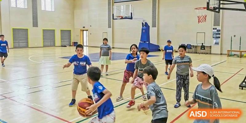 Students play basketball in a gymnasium at Qingdao No.1 International School of Shandong Province (QISS).