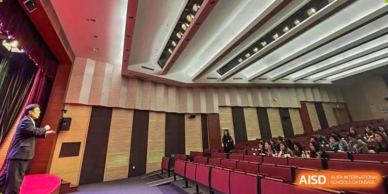 The interior of a large auditorium with rows of red seats at Qingdao No.1 International School of Shandong Province (QISS).