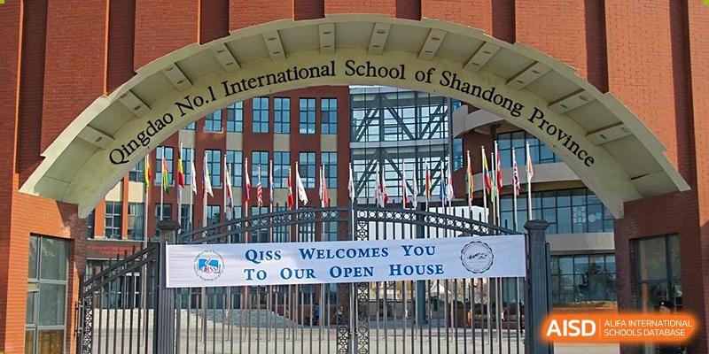 The front entrance of Qingdao No.1 International School of Shandong Province (QISS), with a banner welcoming visitors to an open house.