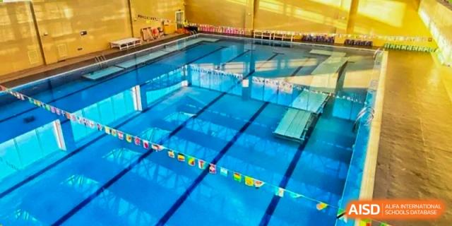 An indoor swimming pool with lanes and flags at Qingdao No.1 International School of Shandong Province (QISS).