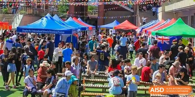 A crowd of people at an outdoor fair or festival at Qingdao No.1 International School of Shandong Province (QISS).