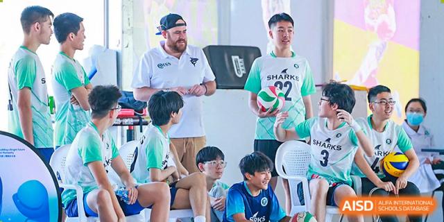 A coach talks to a group of male students during volleyball practice at Qingdao No.1 International School of Shandong Province (QISS).