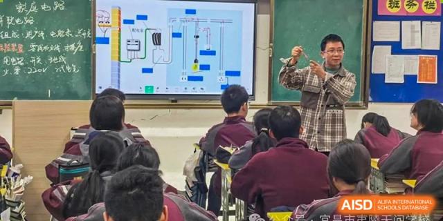 Students sitting at their desks, looking toward a large screen displaying a digital lesson in a modern classroom at Yichang Tianwen International School.