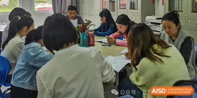 A small group of female students studying or working collaboratively around a table in a bright setting at Yichang Tianwen International School.
