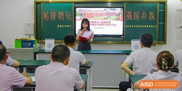 Students watching a female teacher presenting a lesson from a laptop or screen display in the classroom at Yichang Tianwen International School.