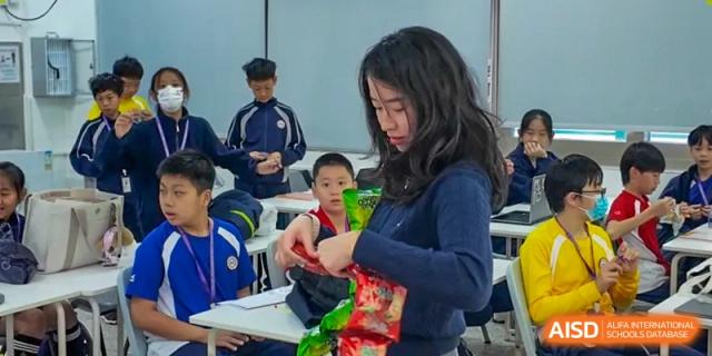 A student from Shenzhen Oasis International School helps a younger student in the classroom.
