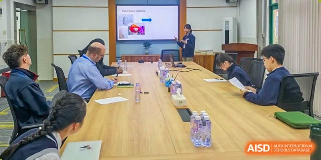Teachers and students from Shenzhen Oasis International School gather around a conference table for a meeting.