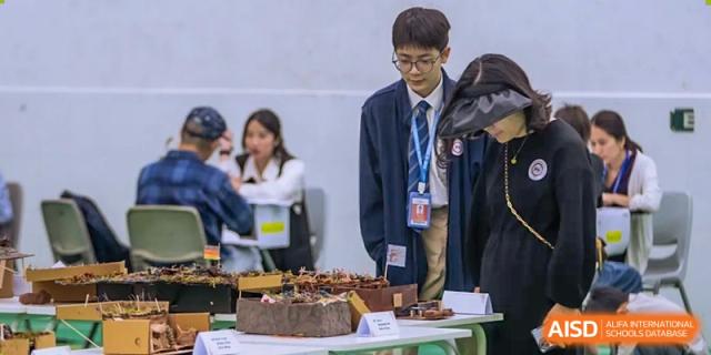 A student from Shenzhen Oasis International School stands next to a birthday cake in a classroom.