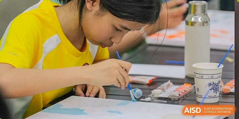 A student from Shenzhen Oasis International School concentrating on painting.