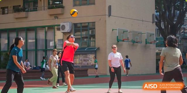 Two students from Shenzhen Oasis International School playing badminton on a court.