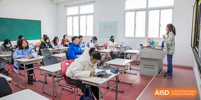 Students from World Leading Schools Association studying and working independently at their desks in a bright classroom.