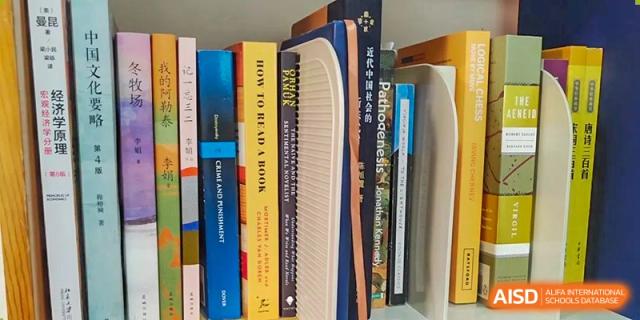 A close-up of a shelf filled with various books, including "How to Read a Book," at World Leading Schools Association.