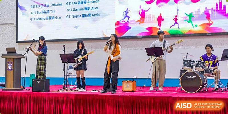 A student from World Leading Schools Association singing and playing a guitar on a stage with a band during a school event.