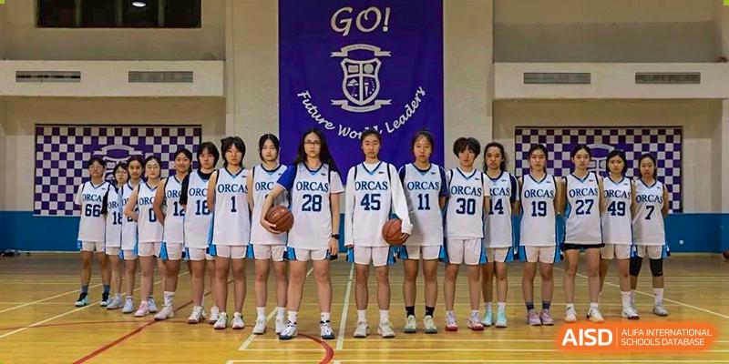 The World Leading Schools Association basketball team posing on the court after a game or practice.