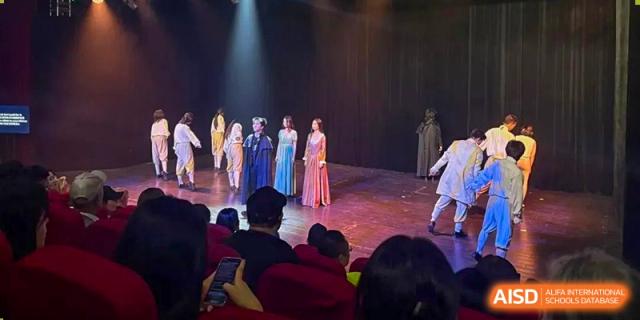 Students from World Leading Schools Association performing a traditional or cultural dance on a stage for an audience.