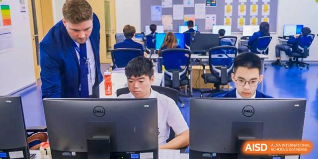 Harrow International School Shenzhen student focused on a computer screen in a classroom setting.