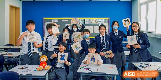 Harrow International School Shenzhen students posing for a photo, holding up their drawings or projects.