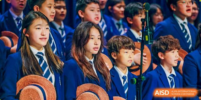 Harrow International School Shenzhen students in their school uniforms, seated and observing an event.