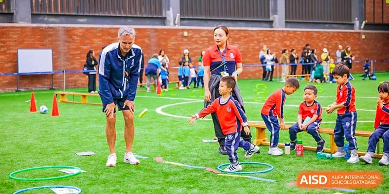 Harrow International School Shenzhen young students participating in an outdoor physical education class, guided by a teacher.