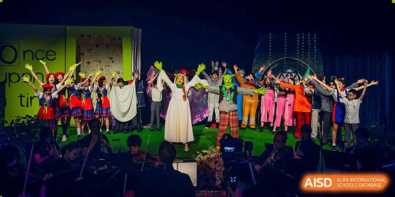 Harrow International School Shenzhen students performing on a stage in a theatrical production with colorful costumes.