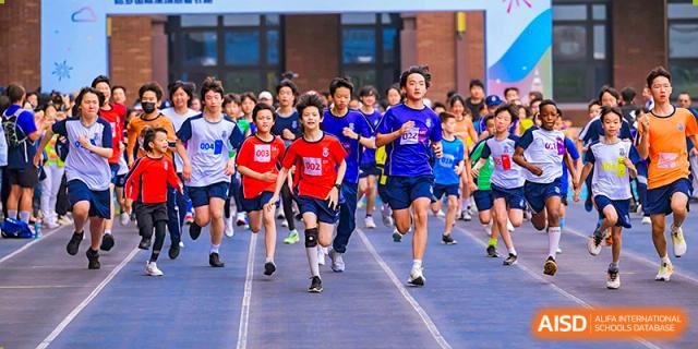 Harrow International School Shenzhen students running a marathon or race on an outdoor track.
