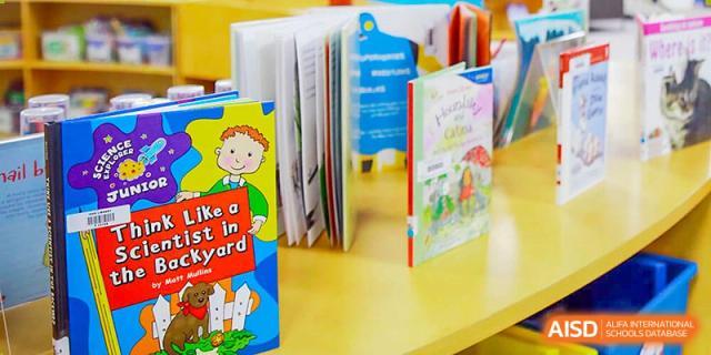 International School of Nanshan Shenzhen various books with colorful covers arranged on a shelf in a library.