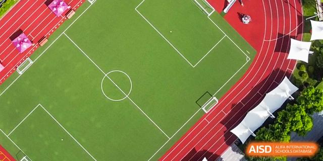 International School of Nanshan Shenzhen bird's-eye view of a soccer field with a red running track surrounding it.