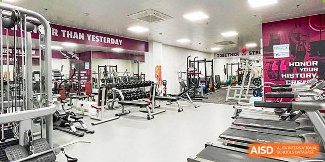 International School of Nanshan Shenzhen school gym with various weightlifting equipment and exercise machines.