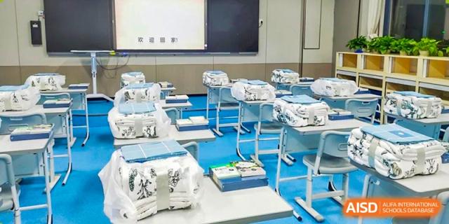 A modern classroom at Shenzhen Yunding School featuring sleek desks, white chairs, and large display screens.