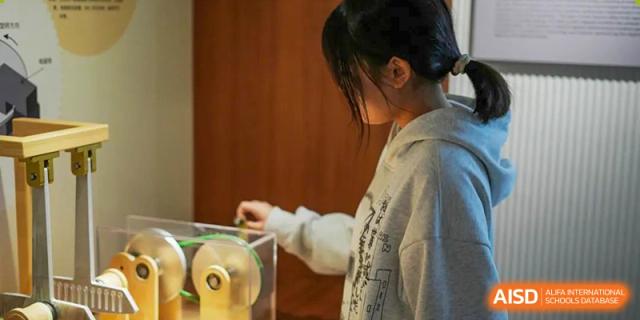 A Shenzhen Yunding School student interacting with a small scientific device or experiment in a hands-on learning activity.