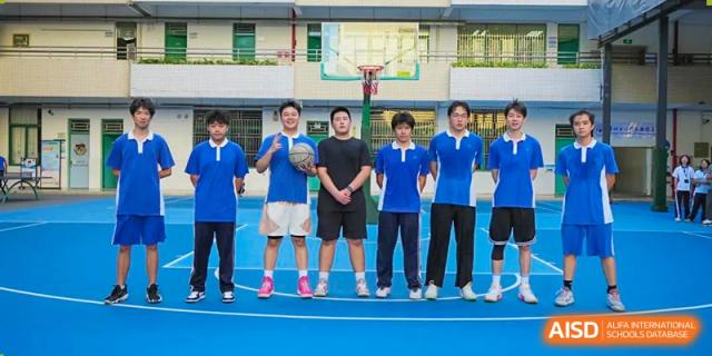 A group of Shenzhen Yunding School students and a coach posing for a photo on a sports court after a game or practice.