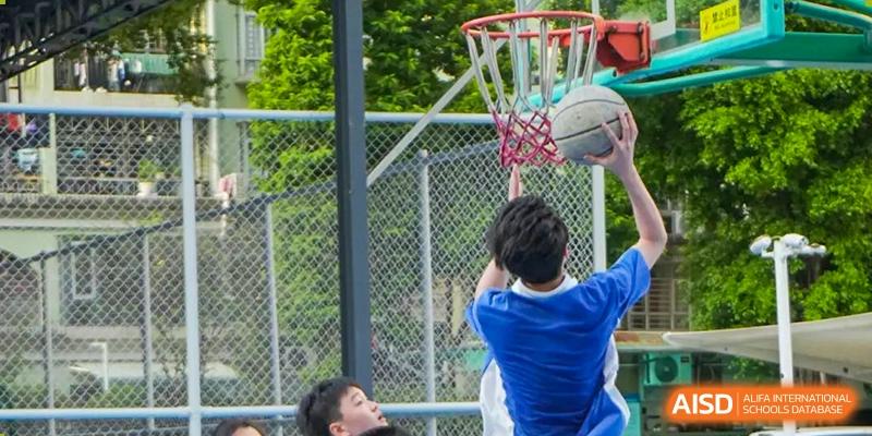 A close-up of a Shenzhen Yunding School student taking a shot at the basketball hoop during an outdoor game.