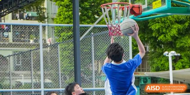 A close-up of a Shenzhen Yunding School student taking a shot at the basketball hoop during an outdoor game.
