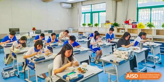 Shenzhen Yunding School students eating lunch or a meal at their desks in a classroom setting.