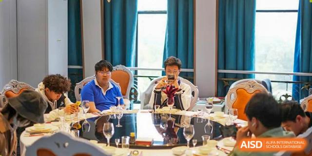 Shenzhen Yunding School adults or faculty members seated at a table, possibly during a formal dinner or meeting.