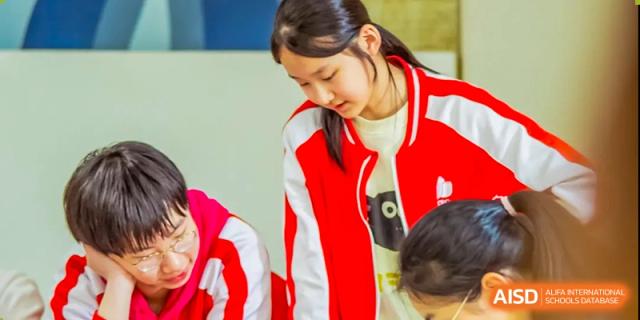 A teacher from Beijing Concord College of Sino-Canada is helping a student with a science project or activity in the classroom.