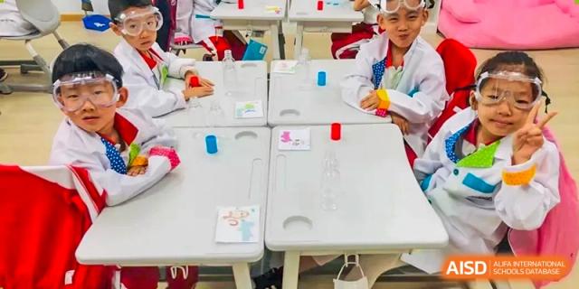 Students from Beijing Concord College of Sino-Canada are working on a science project together in a classroom, with lab equipment on the tables.