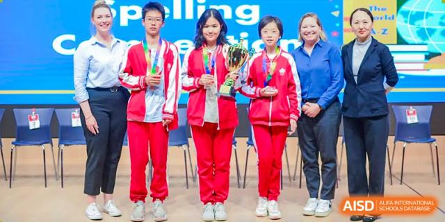 A group of students from Beijing Concord College of Sino-Canada stand together, wearing red and white jackets, possibly for an award ceremony.