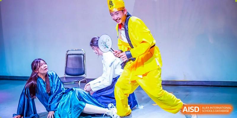 Two students from Beijing Concord College of Sino-Canada, one in white and one in yellow protective suits, are engaged in a simulated rescue or drill.