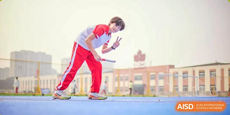 A student from Beijing Concord College of Sino-Canada is performing a trick with a yo-yo on a track during a school event.