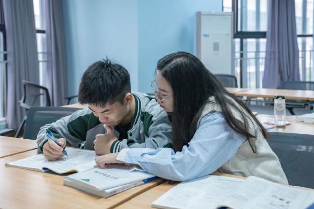 Students from Chongqing BI Academy study together at their desks in a classroom.